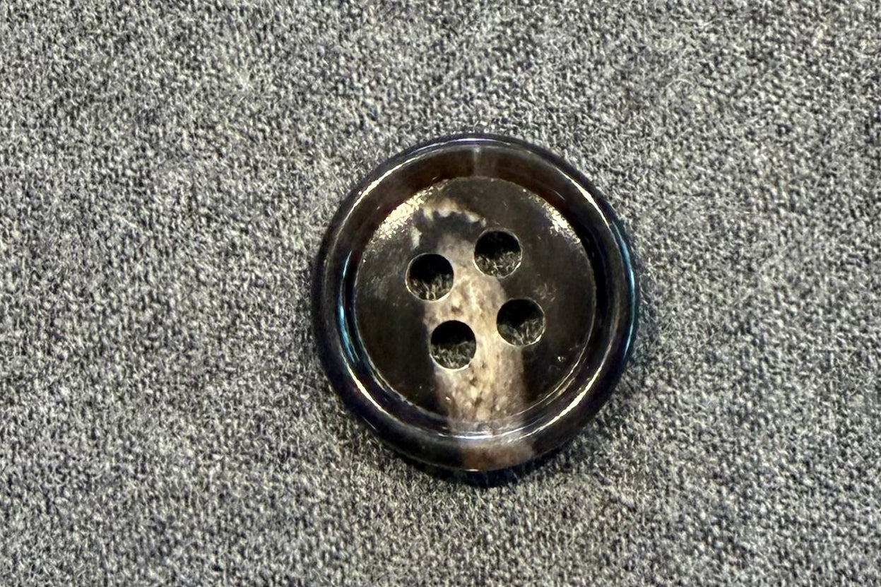 Brown and tan button on a textured gray surface