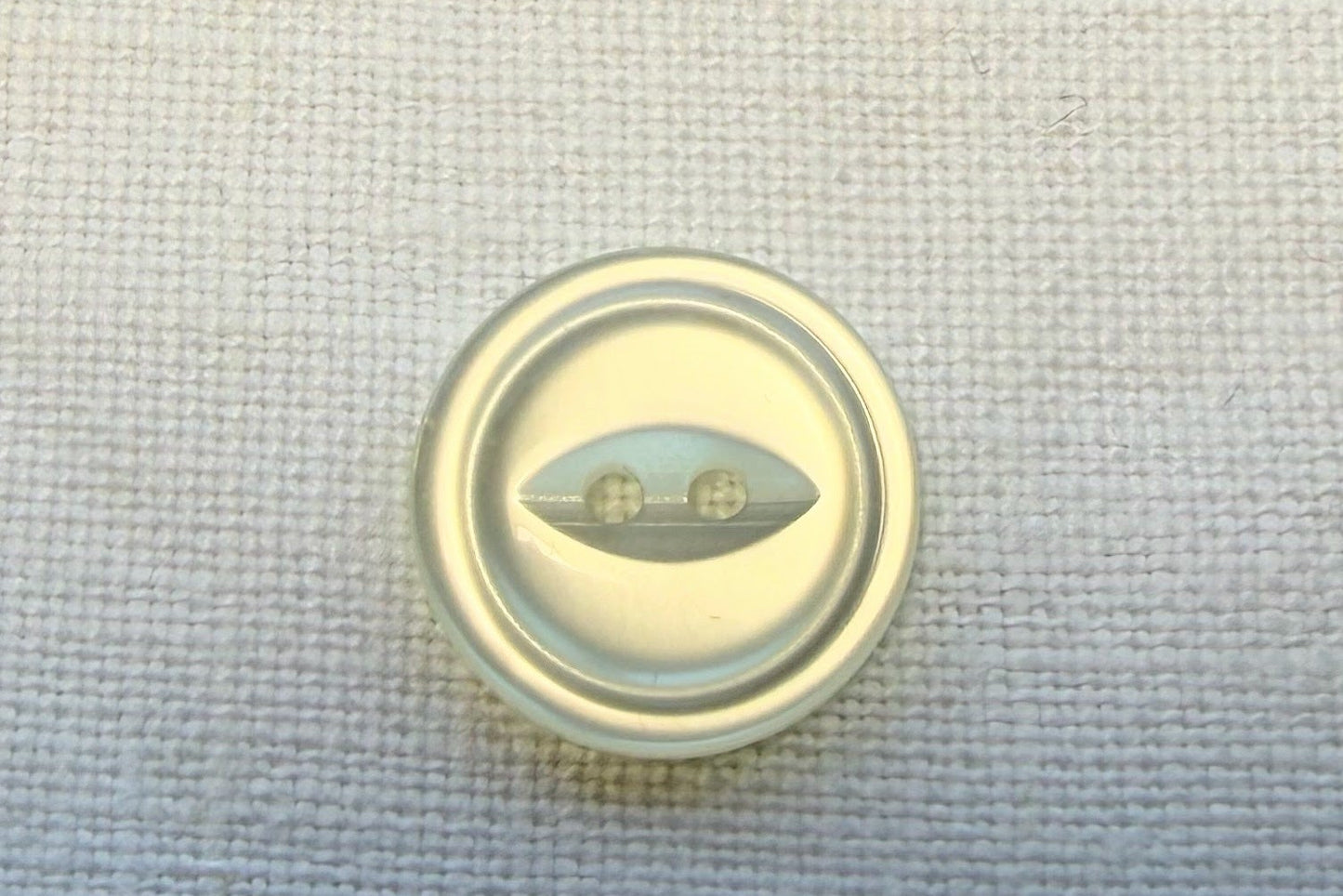White button on a textured white fabric background