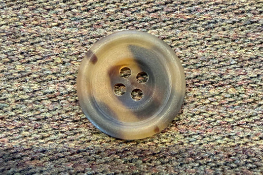 Brown button on a textured fabric background