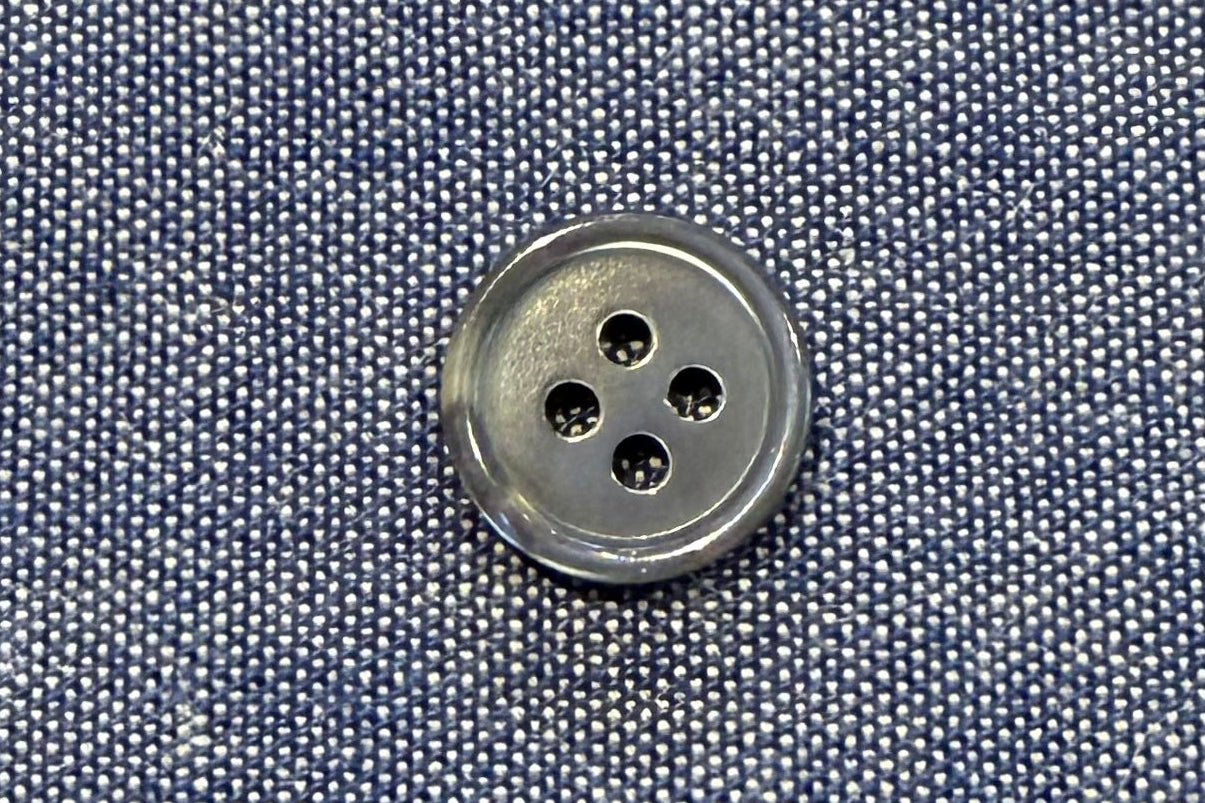Close-up of a button on blue fabric with a textured background
