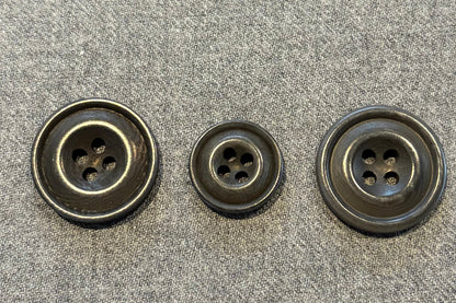 three grey buttons on a textured gray surface