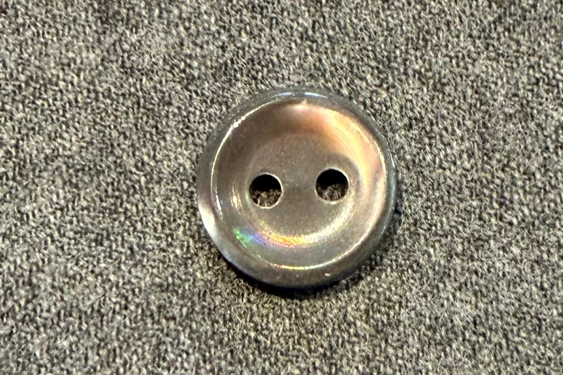 Close-up of a button on gray fabric