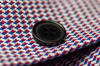 Close-up of a balck button on a red, white, and blue checkered fabric