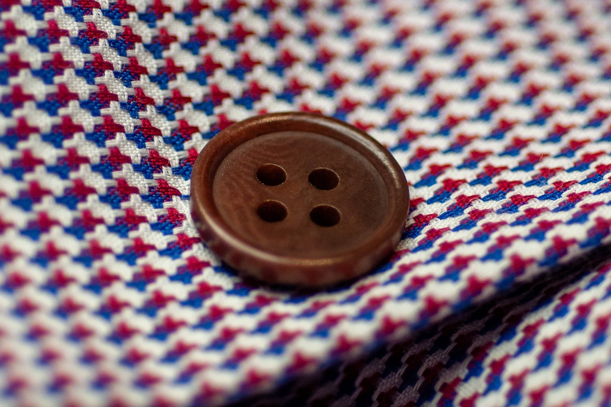 Close-up of a button on a red, white, and blue checkered fabric