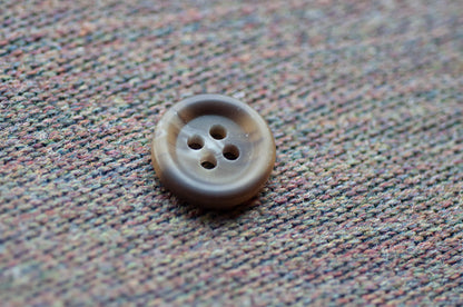 Brown button on a textured fabric background