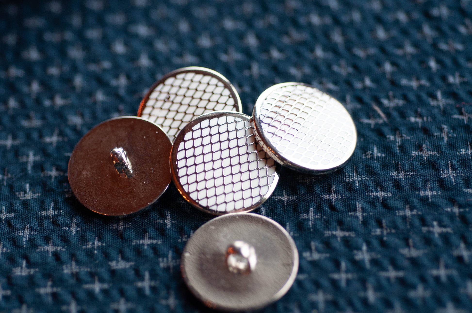 Close-up of metal buttons on a textured fabric background
