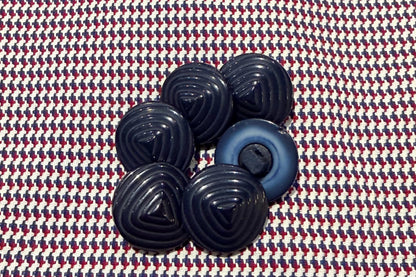 Set of blue plastic buttons on a patterned fabric background