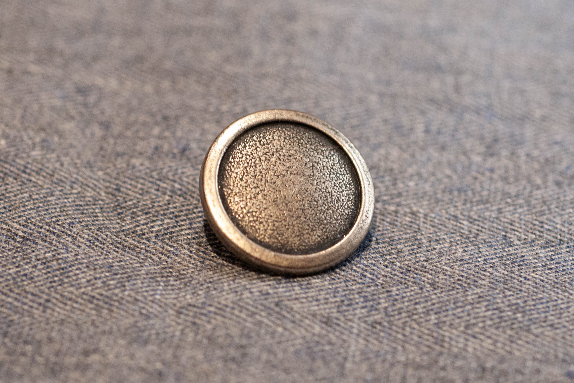 Silver button on a textured fabric background