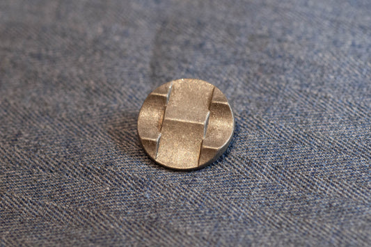 Silver button on a textured gray fabric background
